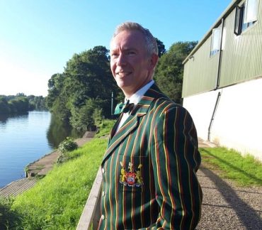 Man in green blazer with red and yellow stripes