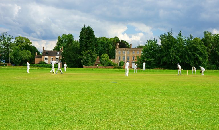 The village green Frampton on Severn, The local cricket team enjoying a game against local rivals. Gloucestershire, England, UK
